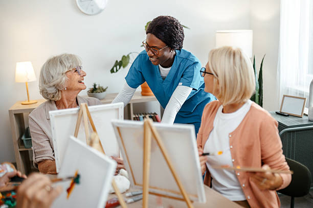 istock Nurse assisting seniors during art activity at nursing home 2221864476