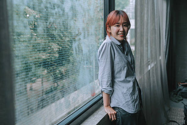 istock Authentic Portrait of a Non-Binary Japanese Individual Smiling by the Window 2221866533