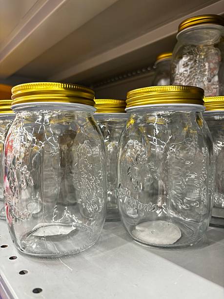Transparent jars with golden lids on a shelf