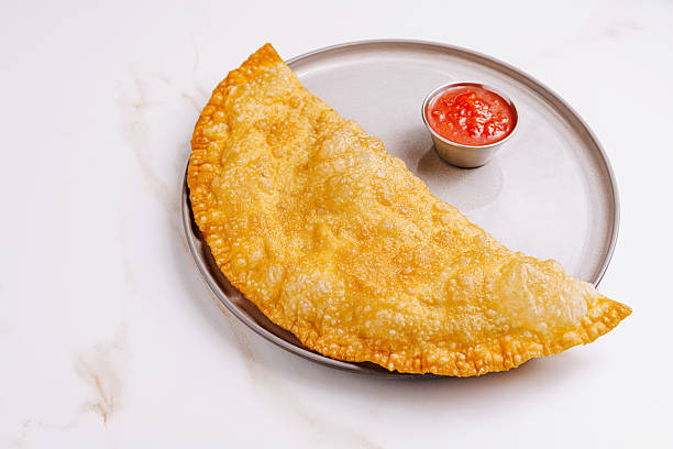 istock Savory crispy empanada served with tangy dipping sauce on a plate 2221874235