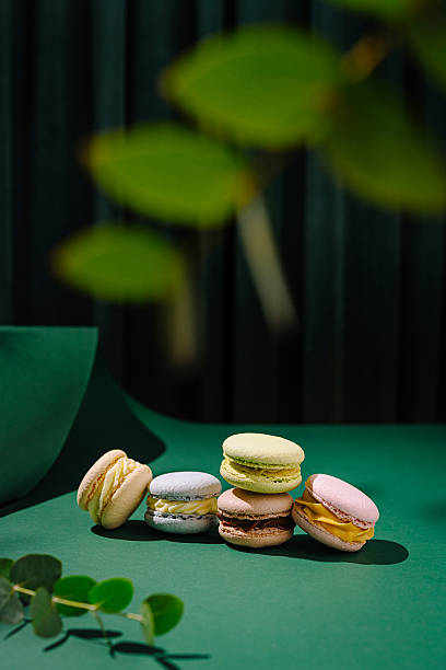 istock Colorful macarons arranged on a textured green surface with leaves 2221874561