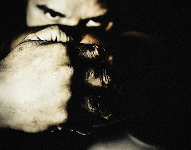 istock ntense male stare behind clenched fists in dramatic low-key lighting. 2221874680