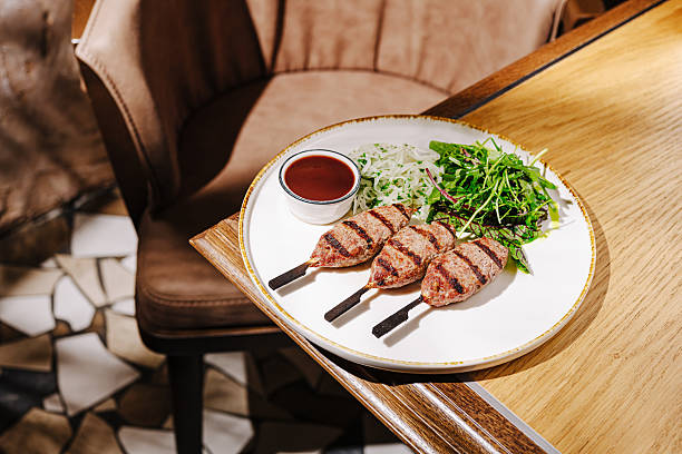 istock Grilled skewers with salad and sauce in a cozy dining setting 2221875354