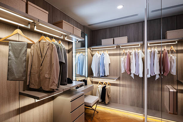 istock Modern walk-in closet with organized clothes and warm lighting 2221876020