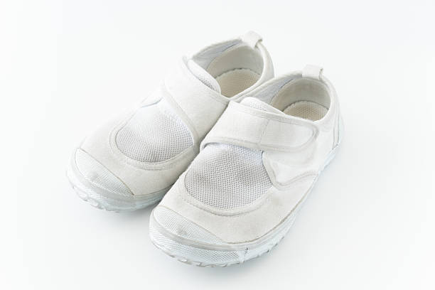 White tennis feet of a little girl hanging from a swing