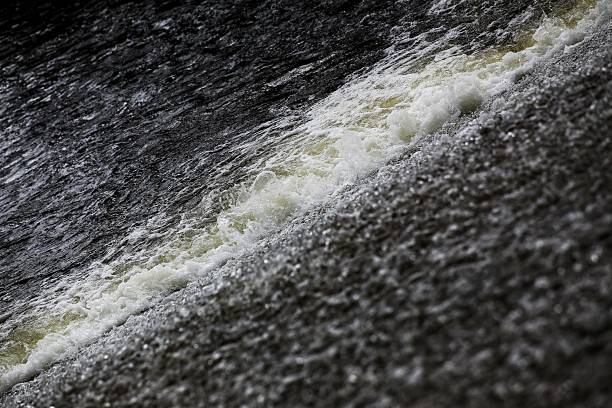 istock Diagonal rushing water showing foamy turbulence across a sloped stream surface 2221878238