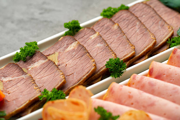 Platter of fresh meat cold cuts with vegetables.
