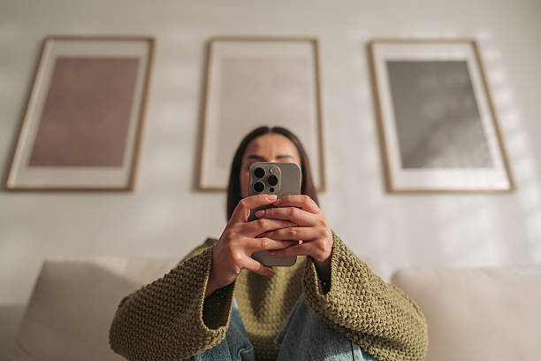istock A Young Woman Actively Engaged in Mobile Technology While Enjoying Relaxation at Home 2221879600