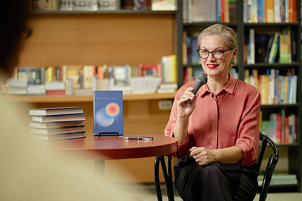 Caucasian Senior Woman Speaking into Microphone during Book Presentation