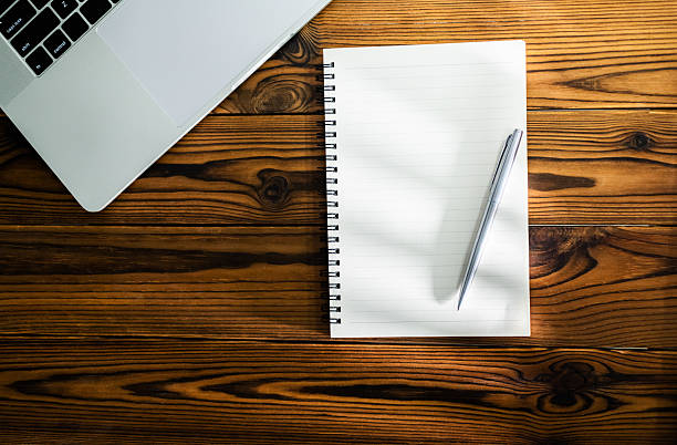 istock Laptop computer, pen and spiral notebook on desk 2221884055