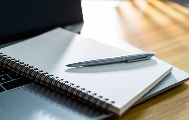 istock Laptop computer with pen and spiral notebook on desk 2221884092