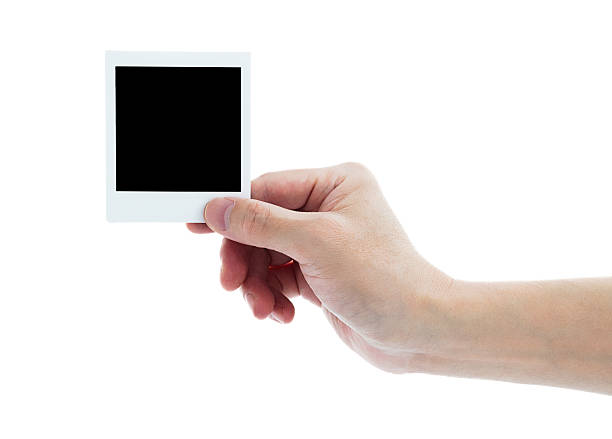 istock Human hand holding blank instant photo card on white background 2221884274