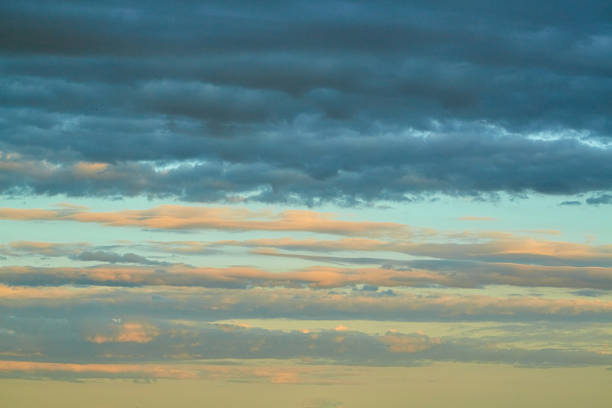 Textured Cumulus congestus illuminated by bright orange-pink light during sunset. A symbol of transition, change, and hope. Applicable in website design, blogs, and artistic projects.