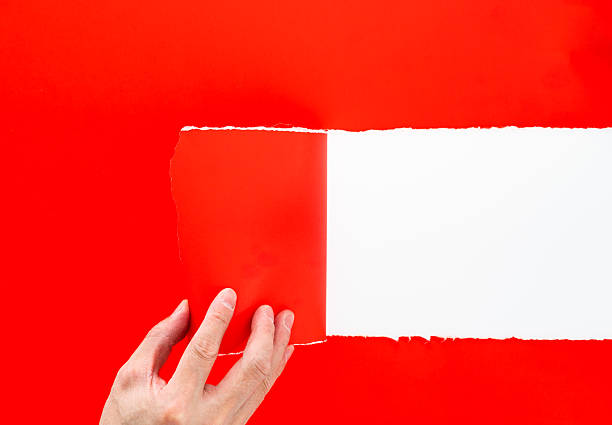 istock Hand tearing a red paper on white background 2221884697