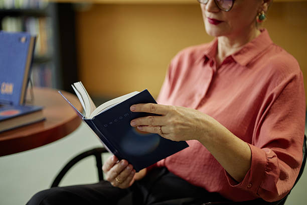 istock Middle Aged Caucasian Woman Reading Book While Sitting in Library 2221885172