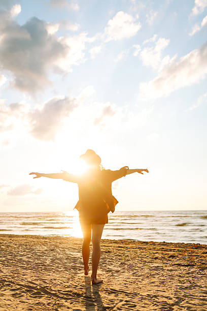 istock Young woman walking on the beach at sunset. 2221888113