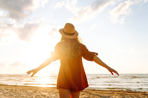 istock Young woman walking on the beach at sunset. 2221888120