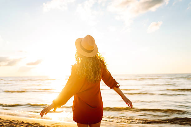 istock Young woman walking on the beach at sunset. 2221888132