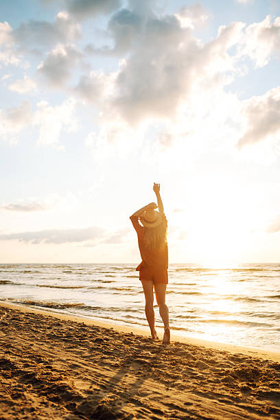 istock Young woman walking on the beach at sunset. 2221888138