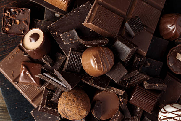 istock Chocolate candies and chocolate pieces pile for background 2221888301