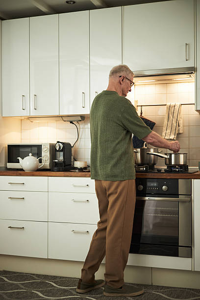 istock Senior Man Cooking in Modern Kitchen Using Stove 2221888325