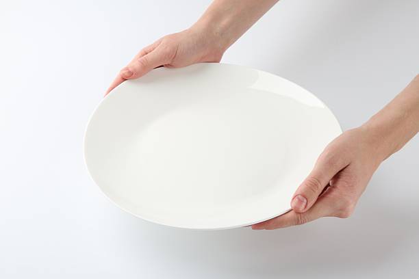 istock Woman with empty ceramic plate on white background, closeup 2221888631