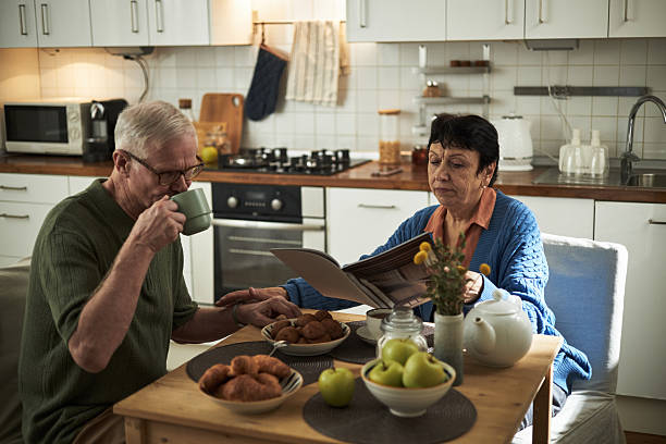 istock Seniors Enjoying Reading and Drinking Coffee in Cozy Kitchen 2221890428