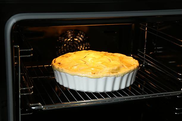 istock Baking dish with raw homemade apple pie in oven 2221890745