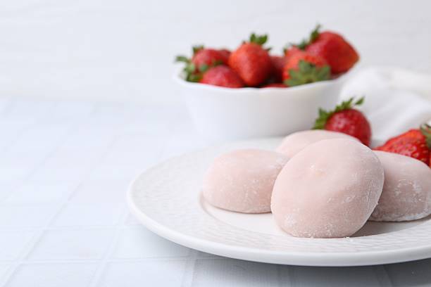 istock Delicious mochi and strawberries on white tiled table, closeup 2221891008