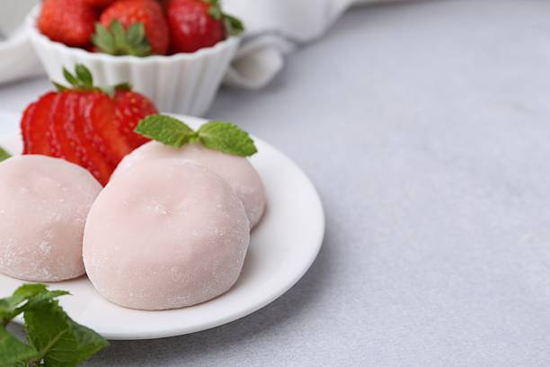 istock Delicious mochi, strawberries and mint on light grey table, closeup. Space for text 2221891552