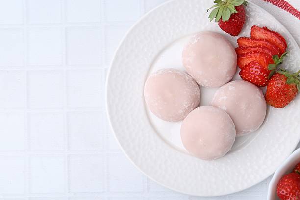 istock Delicious mochi and strawberries on white tiled table, top view. Space for text 2221891639