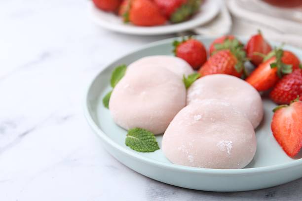 istock Delicious mochi, strawberries and mint on white marble table, closeup 2221891651