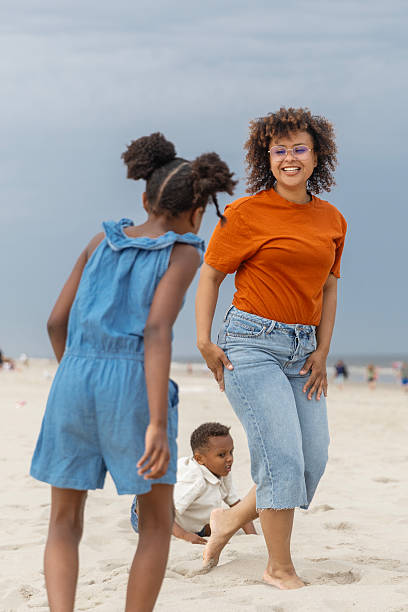 istock Diverse mother, daughter & son enjoying a Spring day on the beach 2221891675