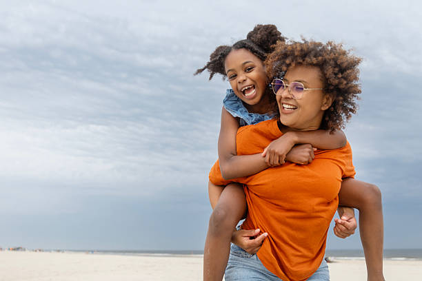 istock Diverse mother and young daughter enjoying a Spring day on the beach 2221891830
