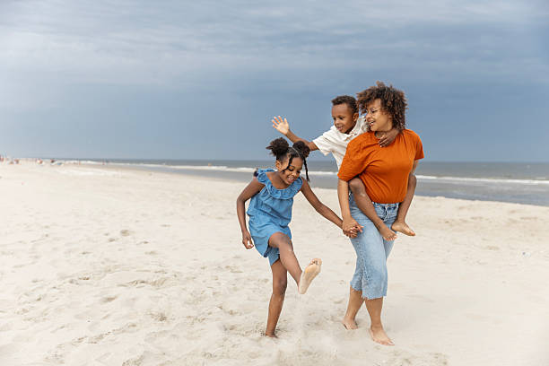 istock Diverse mother, daughter & son enjoying a Spring day on the beach 2221891940