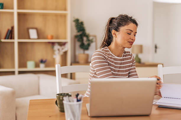 istock Focused woman working from home on laptop and taking notes 2221892627