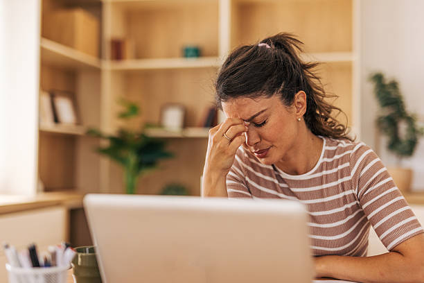 istock Stressed young woman suffering from headache while working from home 2221892934