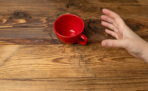 istock Hand Holds Cup, Empty Red Cup in Hands, Coffee Mug, Teacup, Hot Beverage Mockup 2221894249