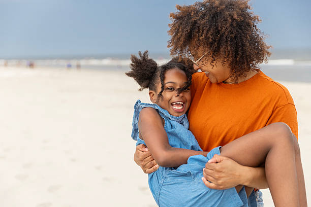 istock Diverse mother and young daughter enjoying a Spring day on the beach 2221895132