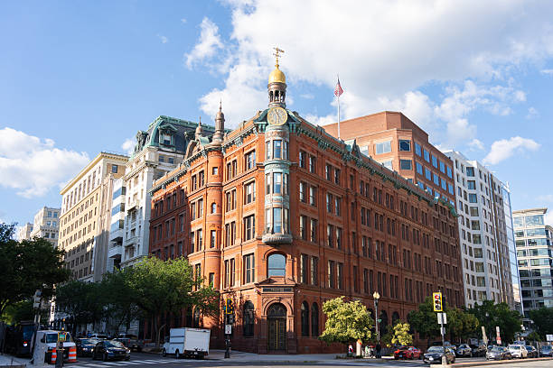 The image showcases historic architecture in Washington DC, featuring prominent buildings along the National Mall. The vibrant greenery adds to the charm of this iconic area on a bright, sunny day.