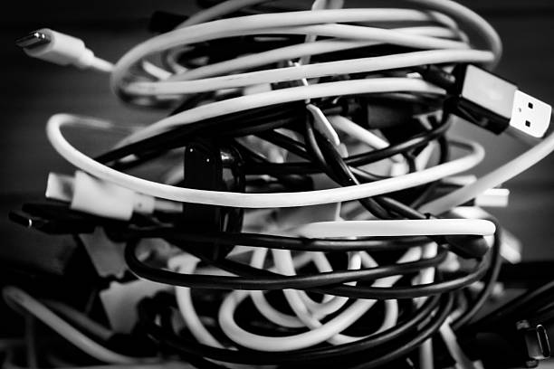 a cluttered pile of cables for charging or powering electronic devices. technology clutter design element
