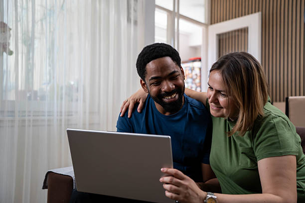 istock Couple at home making a reservation online using their laptop 2221898517