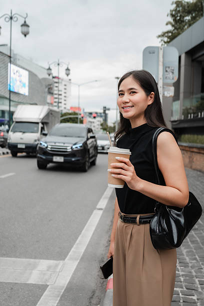 istock Smiling businesswoman savoring a takeaway coffee while strolling through a bustling city street, embracing the energy of urban life 2221901074