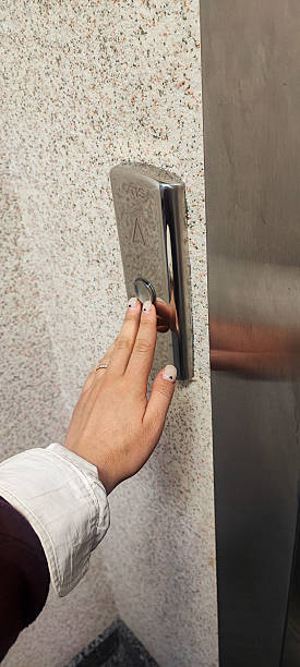 istock Finger Pressing Button in Modern Elevator Interior - Stainless Steel Lift Panel, Urban Movement, Accessibility, Transportation, and City Lifestyle 2221904230