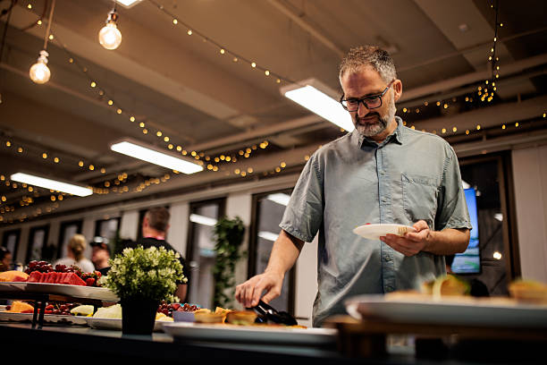 istock Man Selecting Food from Buffet in Modern Dining Space 2221909450