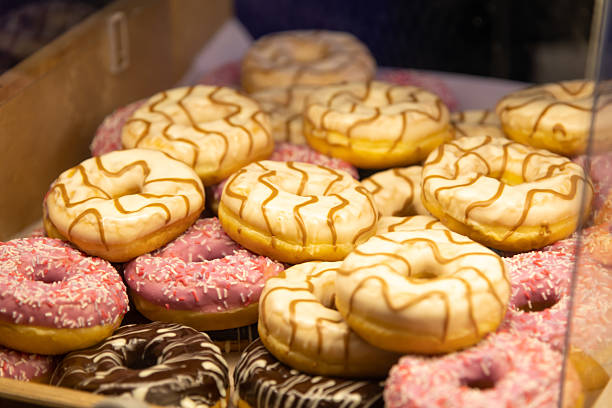 istock Colorful assortment of donuts displayed at a bakery counter 2221911410
