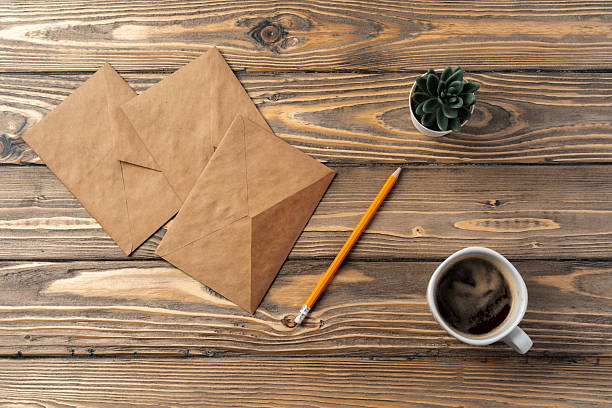 istock Vintage envelope with empty card, pen on wooden table top view 2221912297