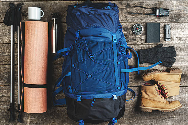 istock Backpack and hiking equipment on wooden background, top view 2221914514