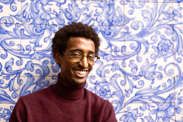 istock Smiling man against decorative blue wall 2221917370