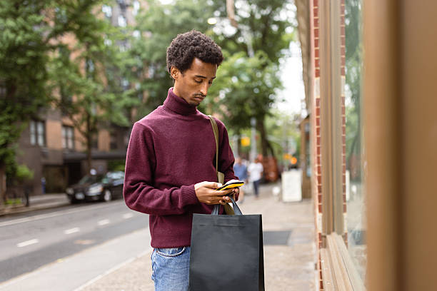 istock Solo Shopper Checking Phone Outdoors 2221917383
